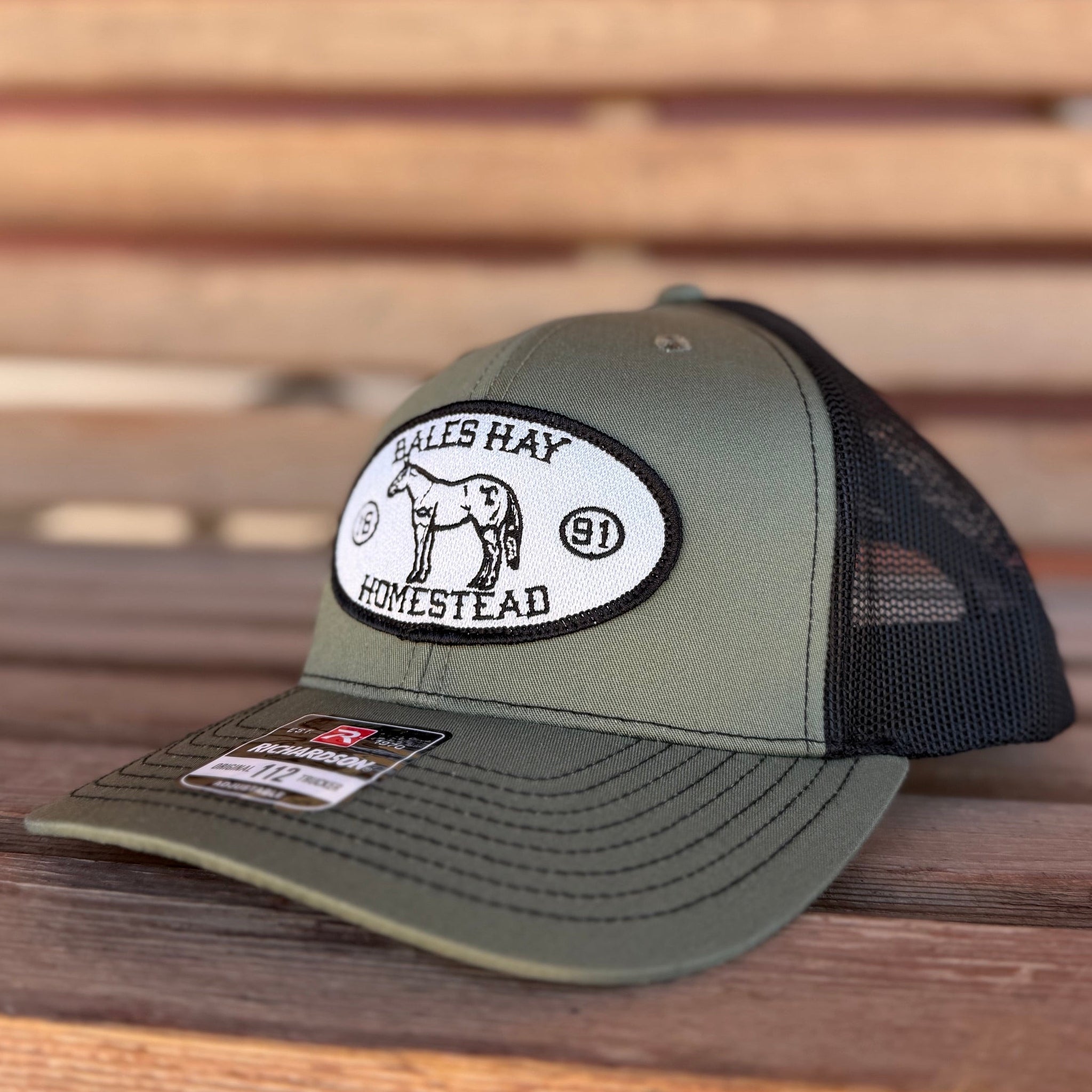 Green and black cap with a logo on a wooden surface