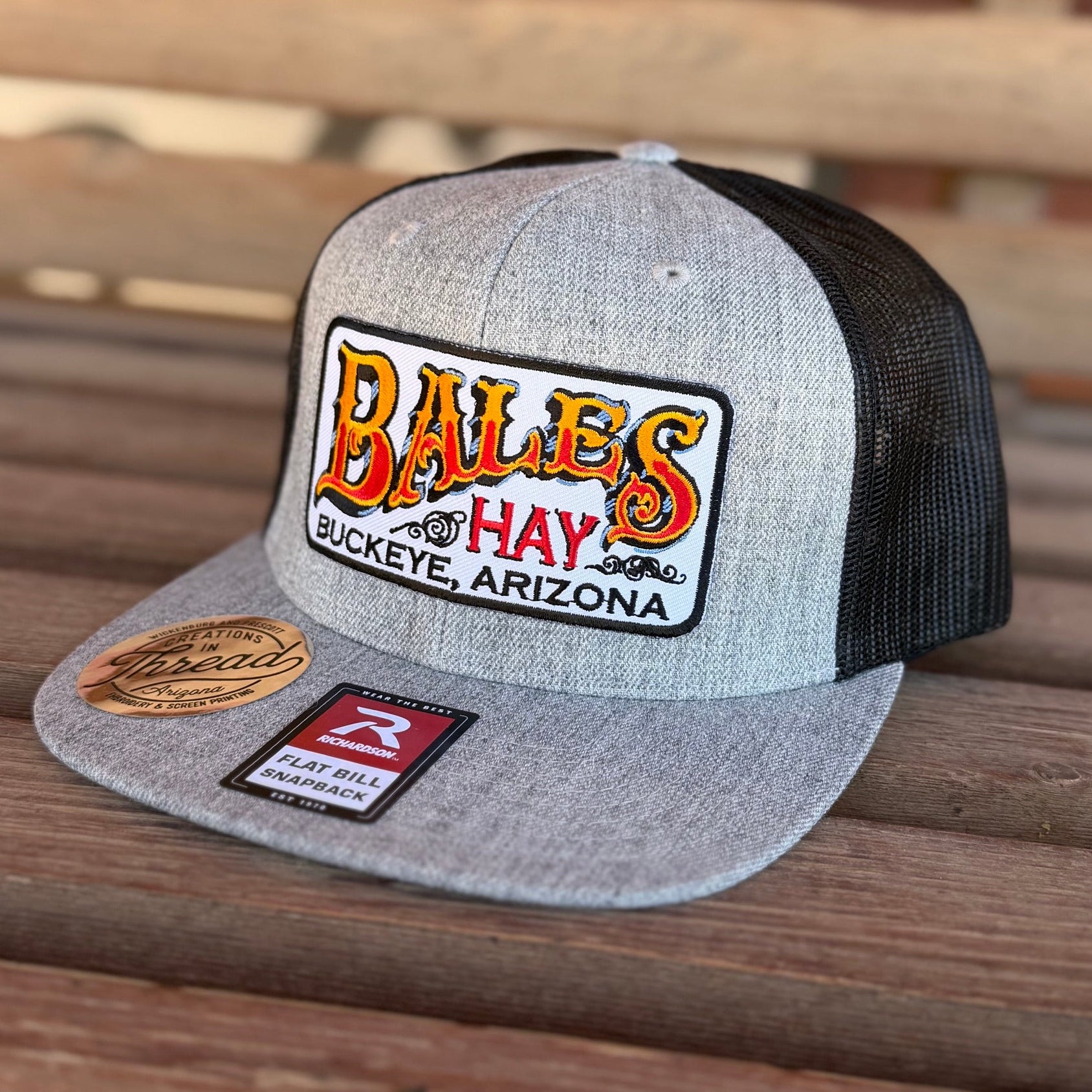 Gray and black cap with a logo on a wooden surface