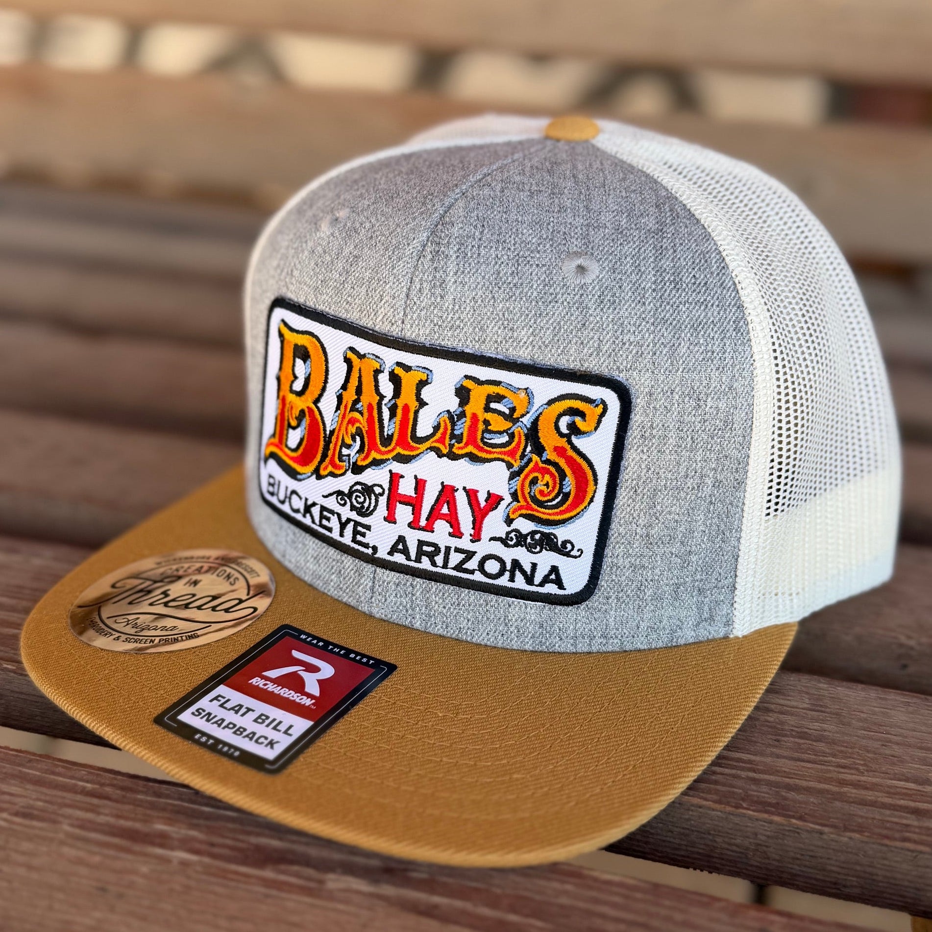 Gray and brown cap with a logo on a wooden surface