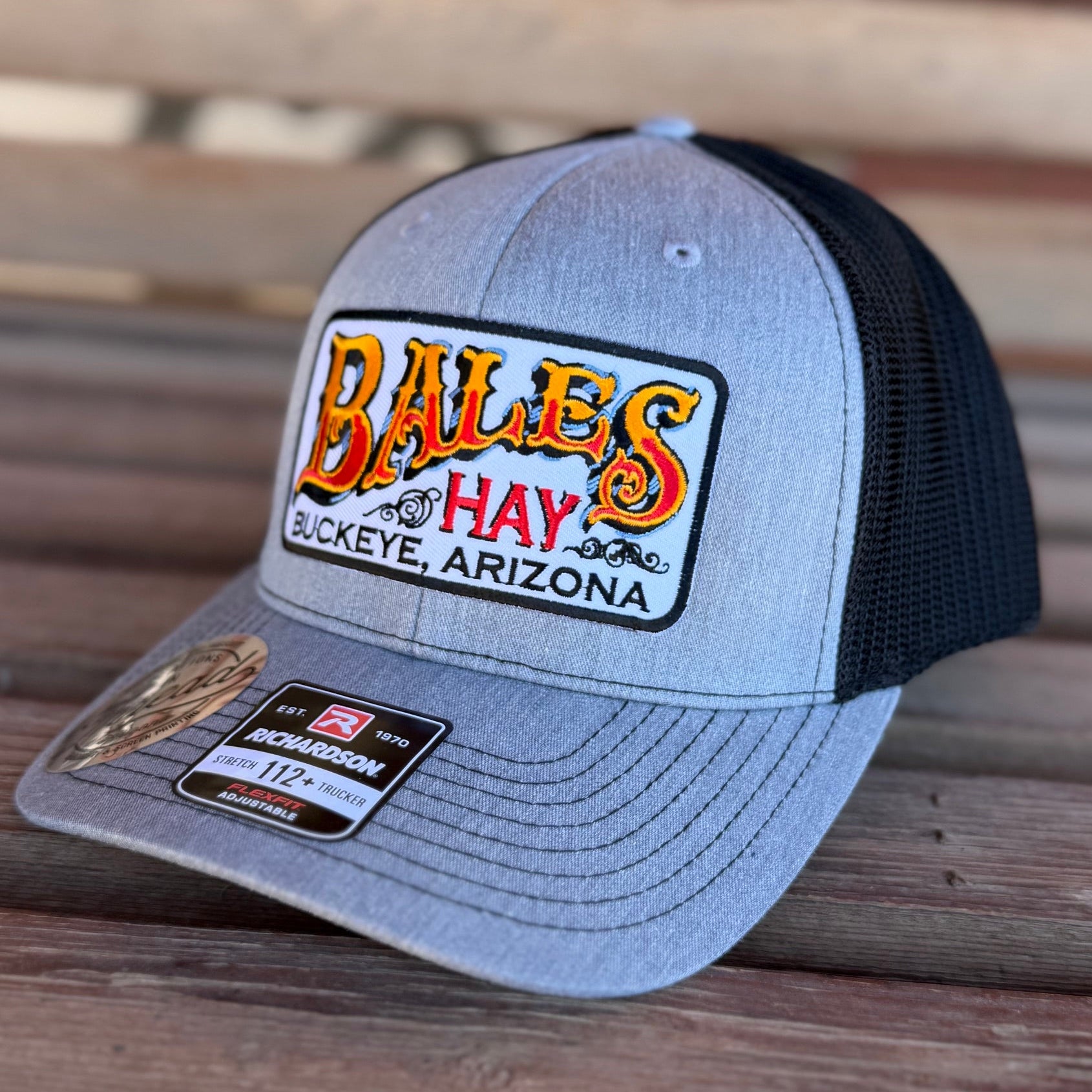 Gray and black cap with a logo on a wooden surface