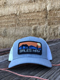 Load image into Gallery viewer, This hat is both well-made and comfortable to wear that features the first patch we ever designed! It represents the horses we feed, and the landscape we live in.  
